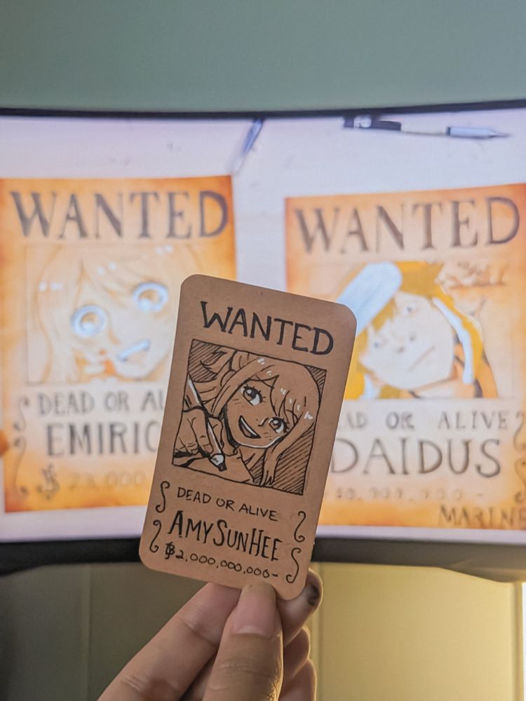 Sketch by AmySunHee of mini one piece wanted poster in front of Spilled Ink YouTube video where Emirichu and Daidus show off their own wanted poster designs