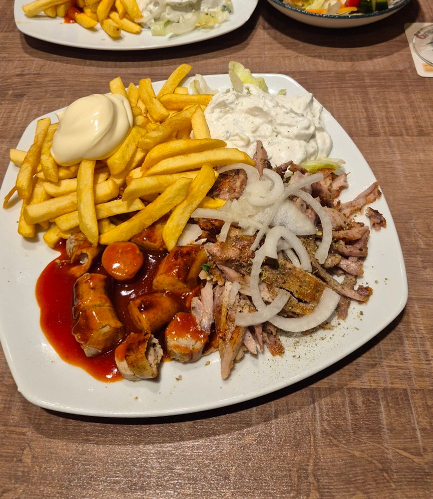ein taxiteller (pommes mayo, tzatziki, currywurst, gyros mit zwiebeln)