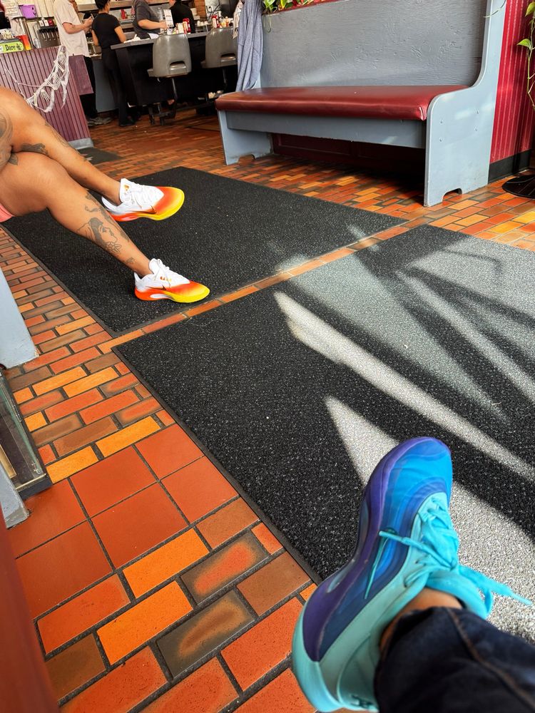 Two Black ladies waiting for milkshakes in a diner. I am wearing blue A'ones. Portia's are candy corn