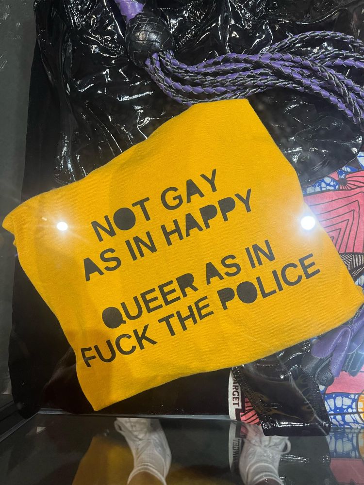 As yellow bit of paper or fabric reading not gay as in happy; queer as in fuck the police. 