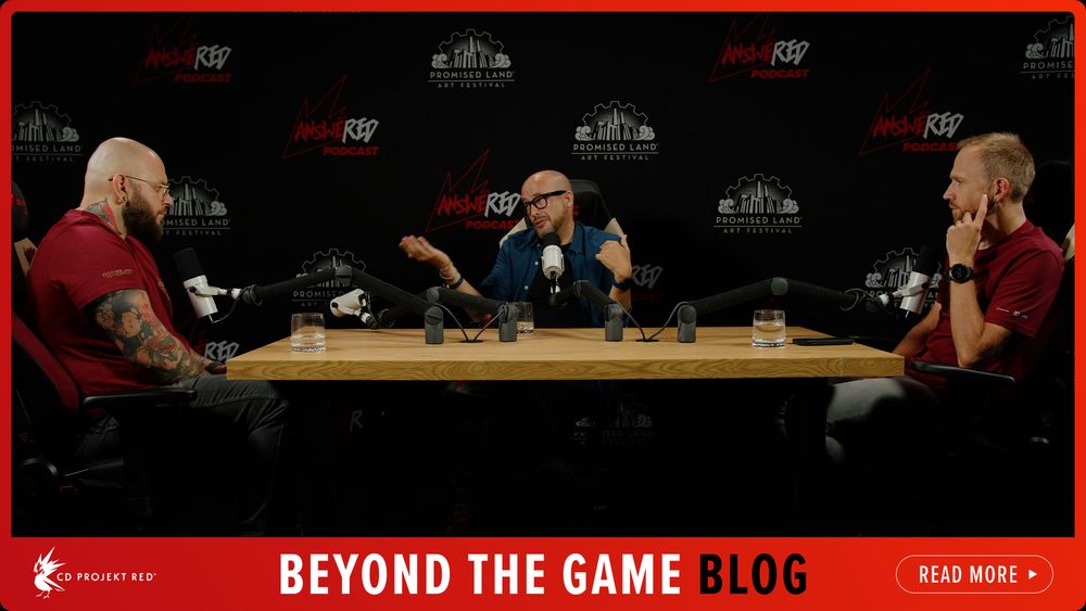 Photograph of Daniel Martínez Lara on set of the AnsweRED Podcast alongside two hosts. The three sit at a wooden table against a black background with logos for the podcast and Promise Land Art Festival on it. A red border surrounds the photo, with the CD Projekt Red logo and text which reads, “Beyond the Game Blog”