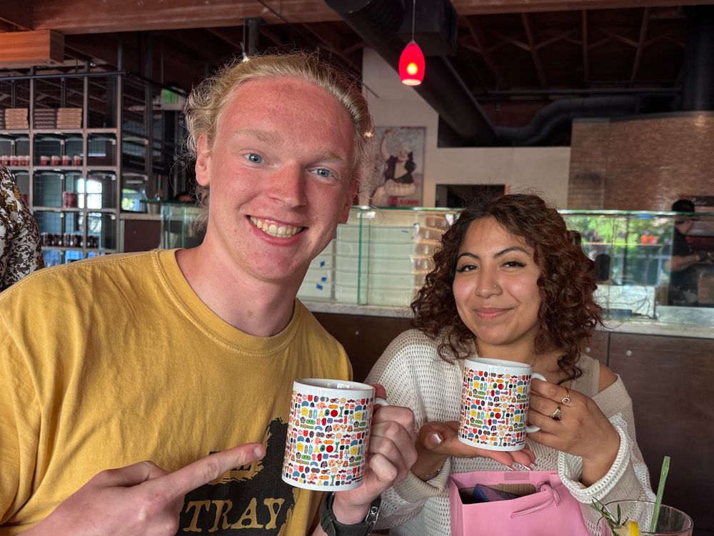 Two senior students posing with their microbe mug. 