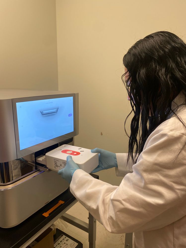 Scientist adding a sequencing cartridge into the sequencing machine 