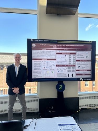 Male undergraduate student presenting his research on a electronic poster on a screen 