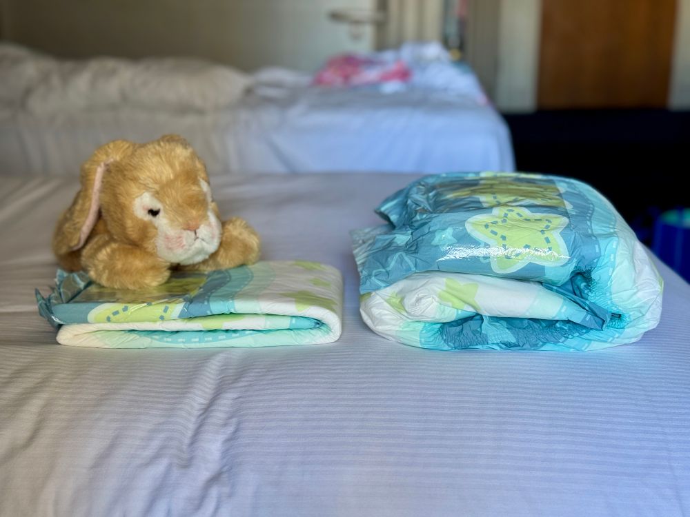 A poofy pins starry night diaper next to a modified starry night diaper which has 3 large stuffers inside 