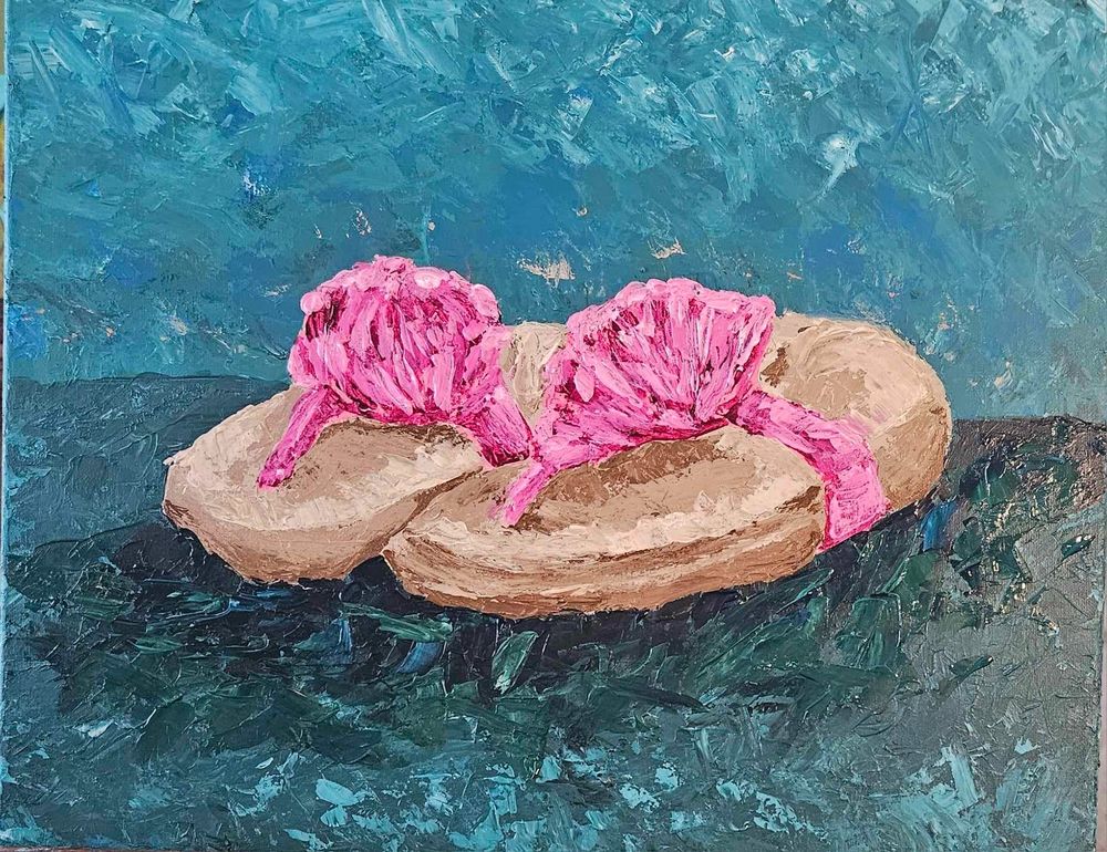 A pair of sandals with brown tones and bright pink tones for the straps. They are topped with bright pink floral shapes and rest on a background in varying shades of turquoise. There is a distinctly lighter turquois blend that separates the background. 