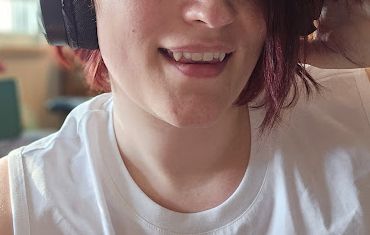 A selfie of myself, cropped to the lower half of the face. I'm showing off my teeth, highlighting that I have extended canines.
