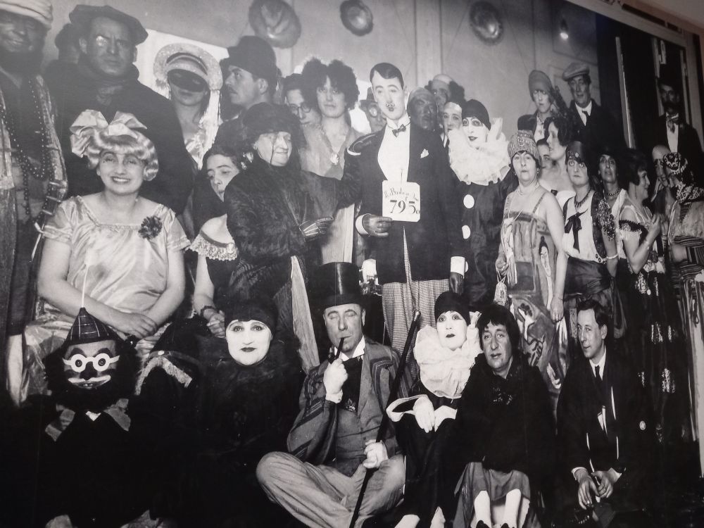 Huge party photo, blown up on the exhibition wall, of a party for Berthe, fancy dress abounds, pierrots galore, she is not evident (there's a short woman near the back whose eye is visible, apparently she disliked being in photos and I think this might be her)