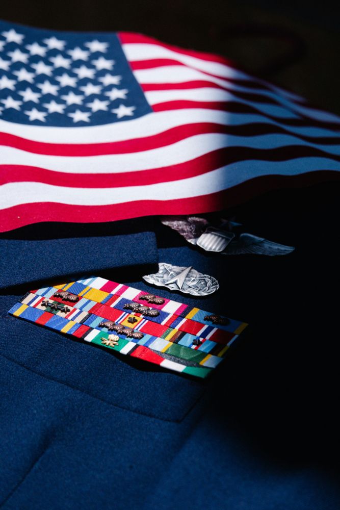 Image of a small US flag laying on a military dress blues jacket.