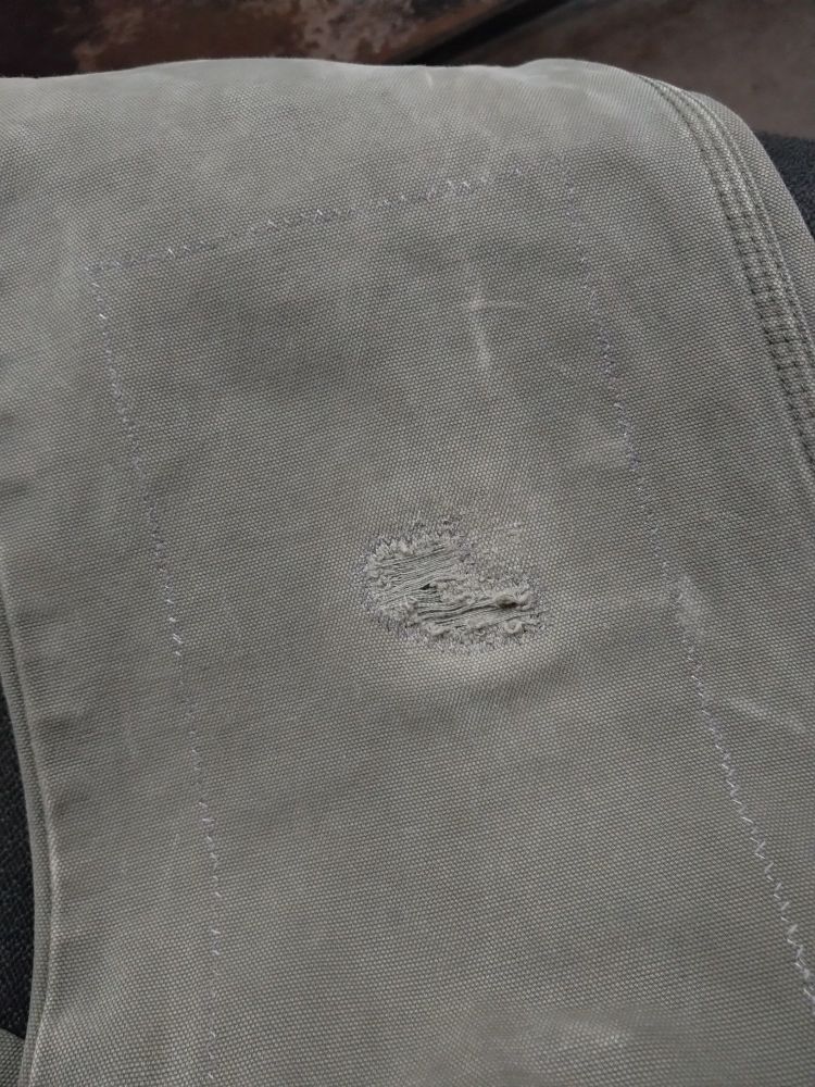 Exterior view of the finished knee patch showing the stitches around the edge of the hole and border of the patch.