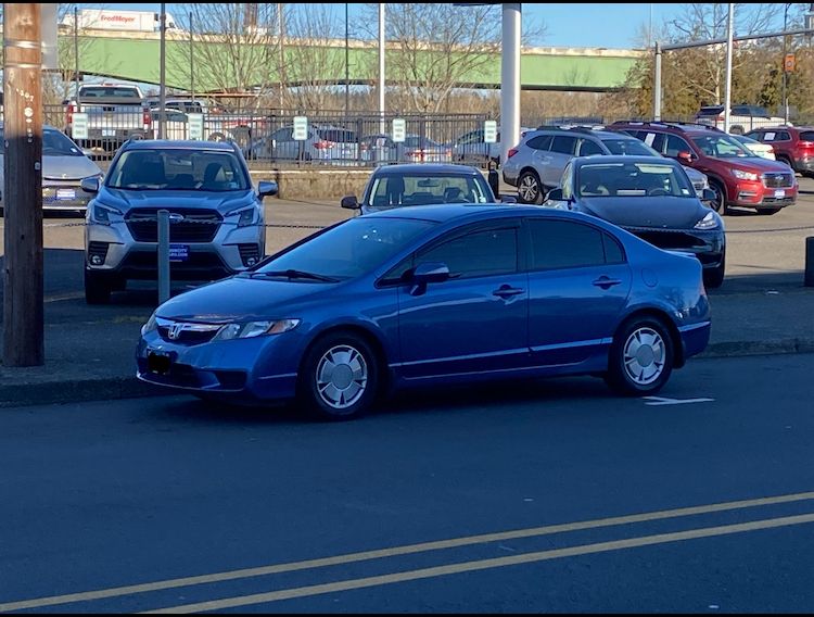 A parked blue 2010 Civic, the license plate numbers have been covered because duh