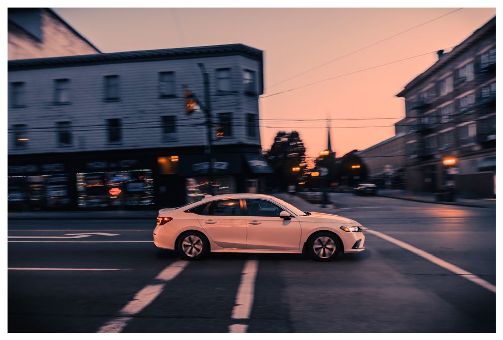Car on street with warm sunlight reflecting on it. 