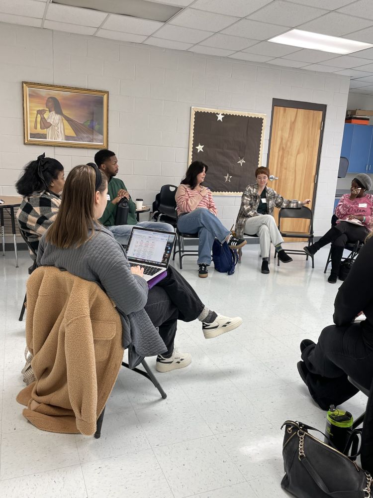 A photograph of ~7 educators seated in a circular formation who are having a focused discussion in a classroom setting at EdCampNash 2025.