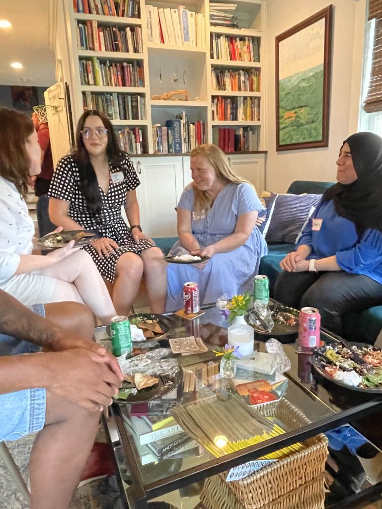 A photograph of ~5 educators conversing around a coffee table.