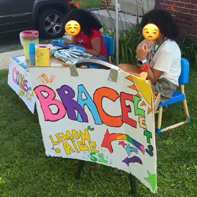 Two little girls at a lemonade and crafts stand