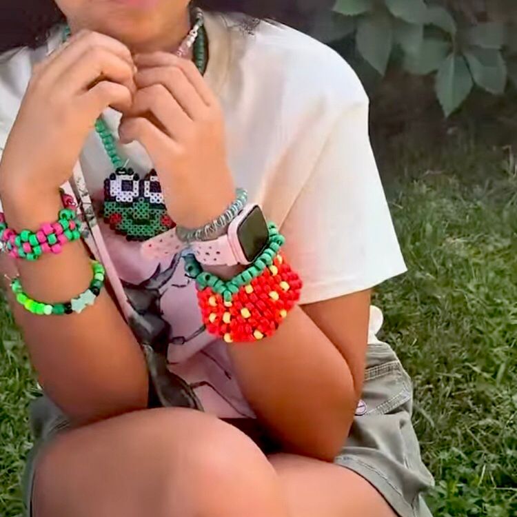 A young girl rocking a bunch of bracelets and necklaces she made.