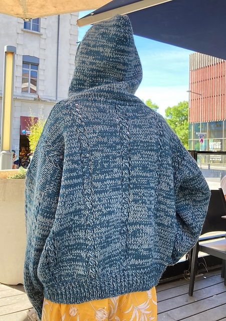 A person standing back to camera wearing a mottled blue hooded sweater. Pattern is Regolith by Kiyomi Burgin.