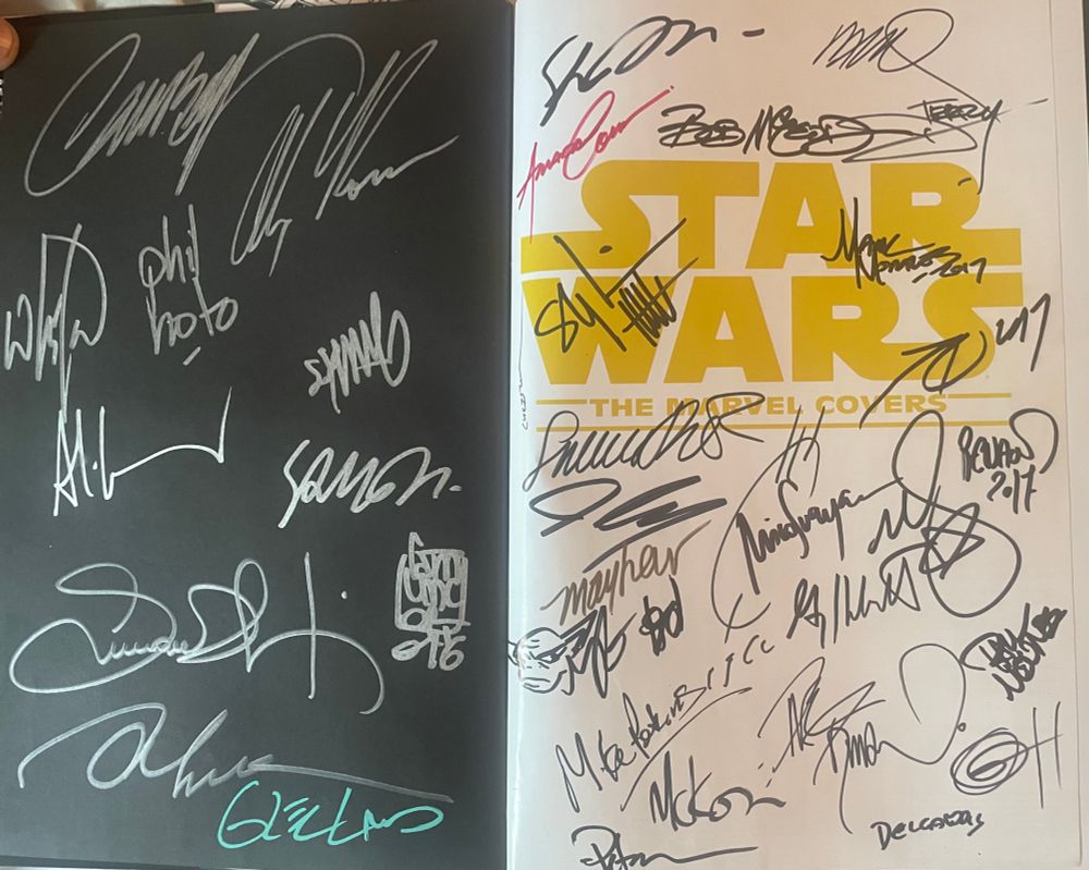 The cover page to The Marvel Covers, absolutely covered in signatures including Alex Ross, Joe Quesada, Phil Noto, John Cassaday, Greg Hildebrandt, John Tyler Christopher, Scottie Young, and many others