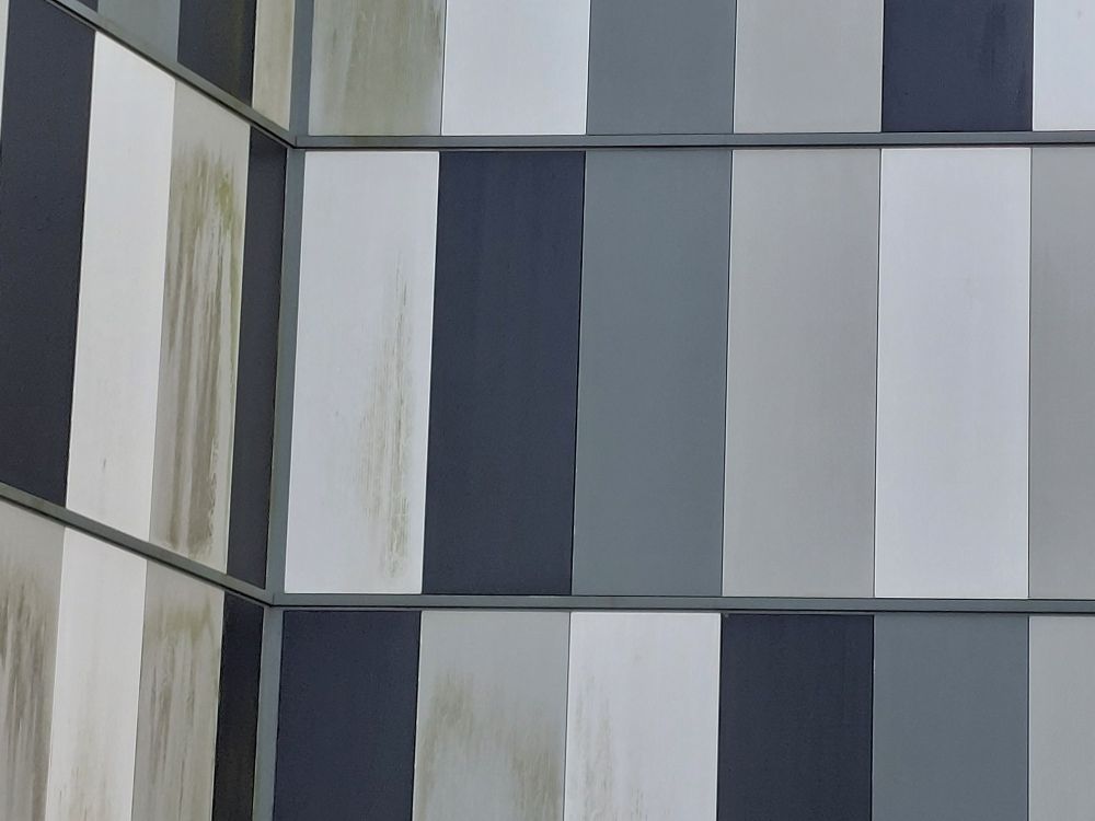 Black, white and grey panels on the side of a multistorey carpark 
