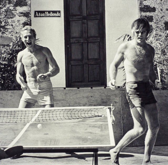 A topless Paul Newman and Robert Redford at one end of a table tennis table 