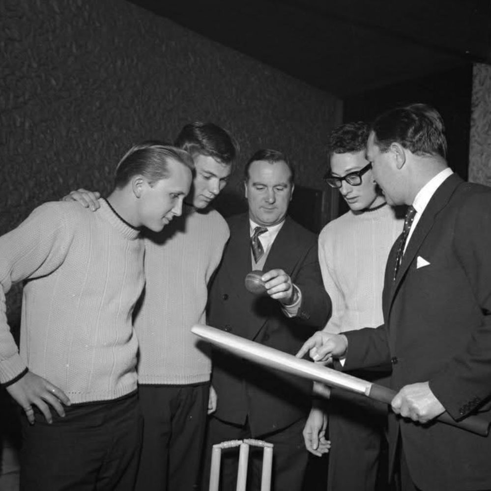 Buddy Holly and the Crickets looking at a cricket bat and a set of stumps 