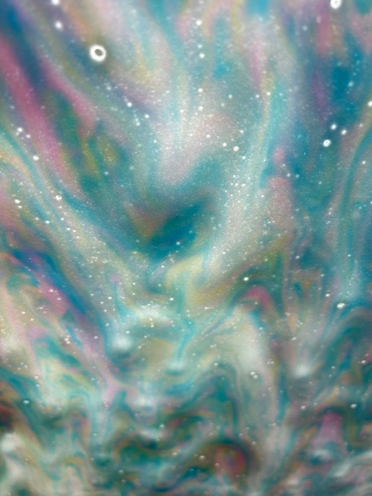 Soap and bubbles forming a tie dye motif on the windshield in a carwash