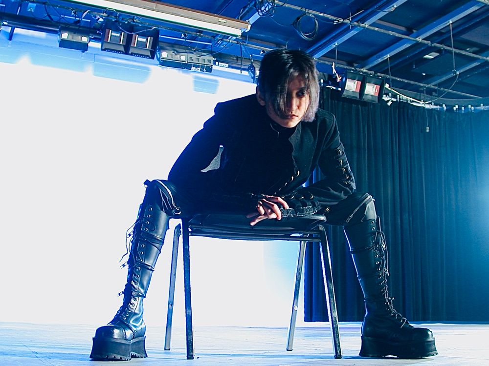 I am sitting on a chair leaning forward.