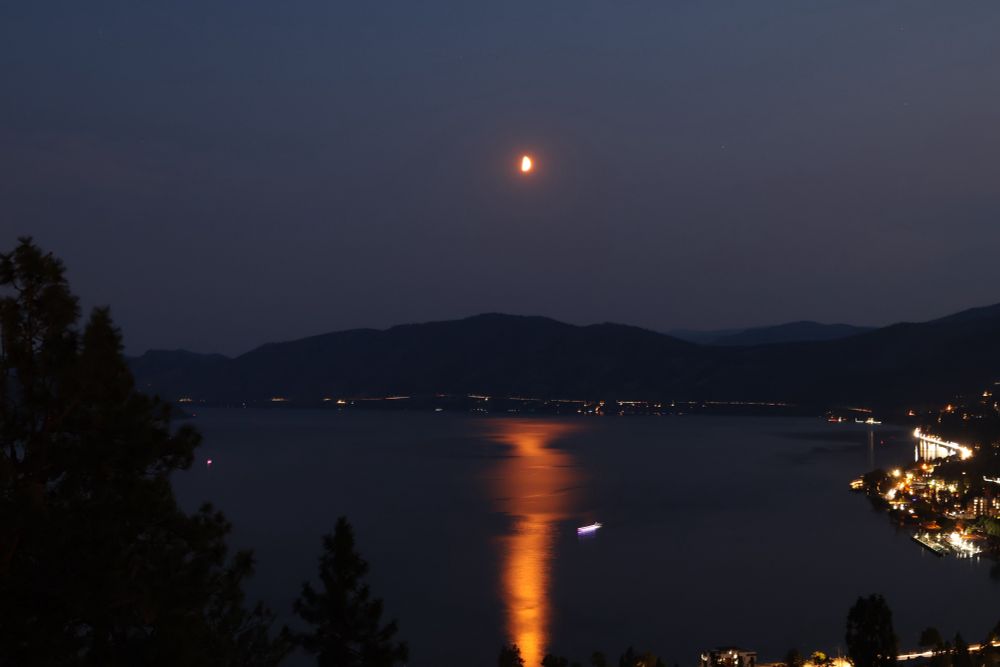 A quarter moon in the sky over Okanagan Lake and Peachland, BC.