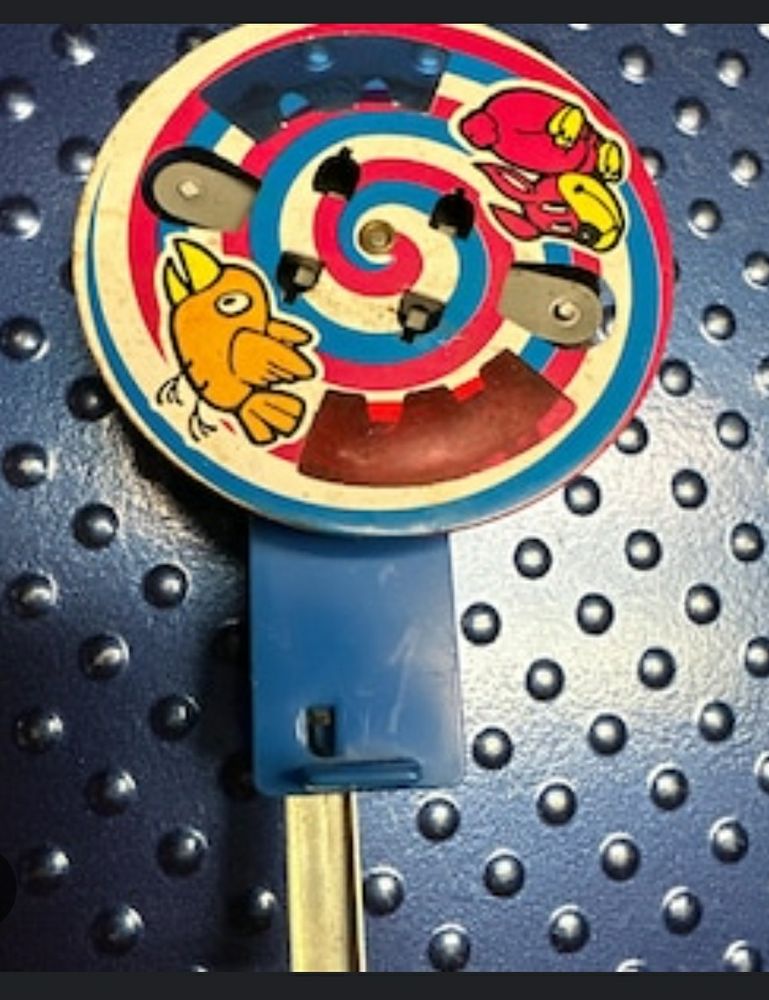 A toy from the 1980s, it is a spinning wheel that makes sparks, and has a picture of a dog chasing a bird on it.