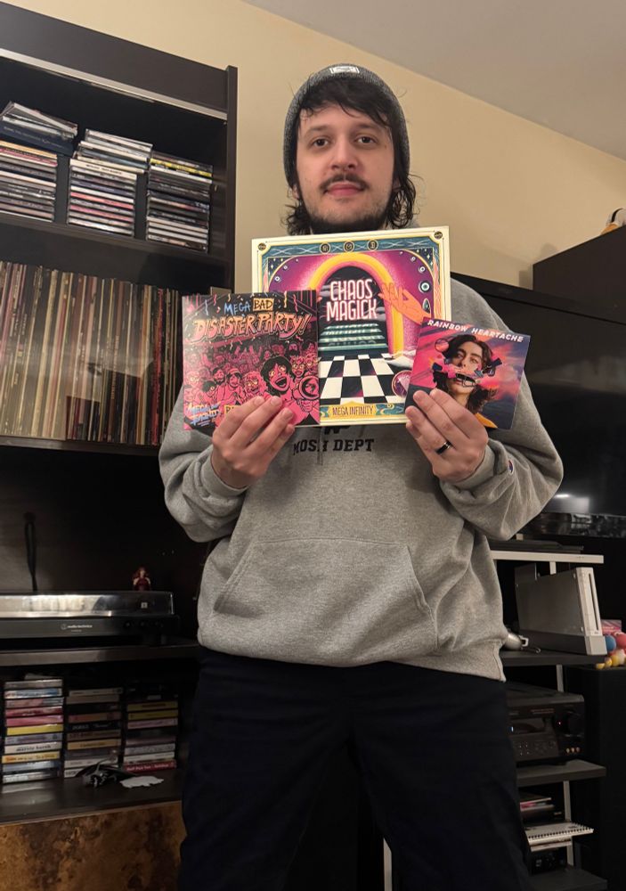Mike holding two mega infinity vinyl and one mega infinity cd