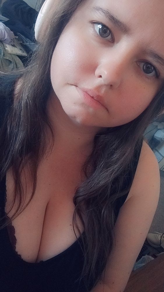 A brunette fem person looking into the camera