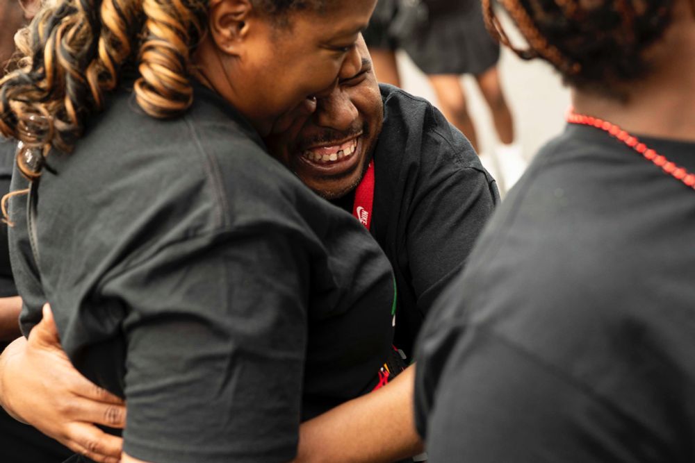 Demetrius Mims grins as he hugs Kim Geiger before they ride The Arc’s float in the Juneteenth parade in Buffalo, June 14, 2025. (Libby March/Buffalo News)