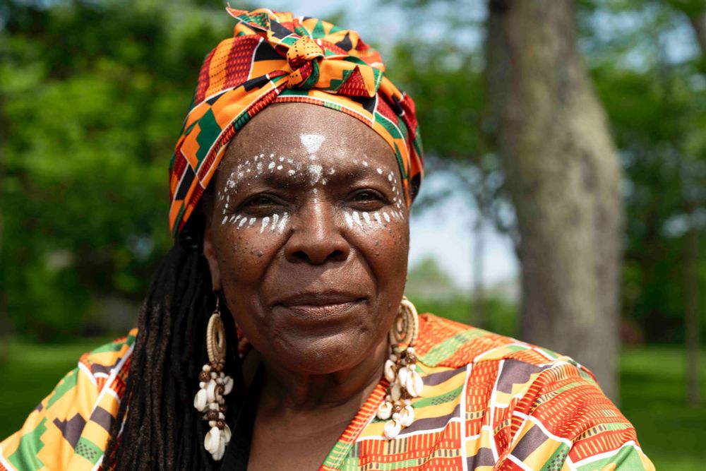 Janice Fayson wears kente cloth and intricate makeup, sitting for a portrait as she watches the Juneteenth parade in Buffalo, June 14, 2025. Fayson said she got the inspiration for her makeup online. (Libby March/Buffalo News)