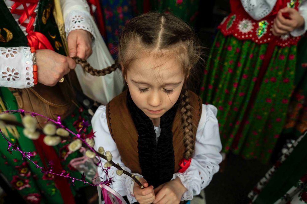 Magdalena Wetula, 6, closes her eyes as her mother, Ela Wetula, braids Magdalena’s hair, attending Dyngus Day festivities at the Pussy Willow Park tent in Buffalo, April 21, 2025. (Libby March/Buffalo News)