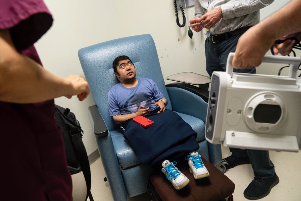 Suneel Ram looks up as doctors ask questions about his breathing machine at UMass Memorial Medical Center in Worcester, Mass., June 13, 2024. The visit to the Duchenne Program at UMass is an annual excursion for Ram and his mother Dr. Neera Gulati. They make the eight hour drive to run extensive physical tests on Ram to gauge the progression of his Duchenne and ensure he is getting the best care possible. (Libby March/Buffalo News)