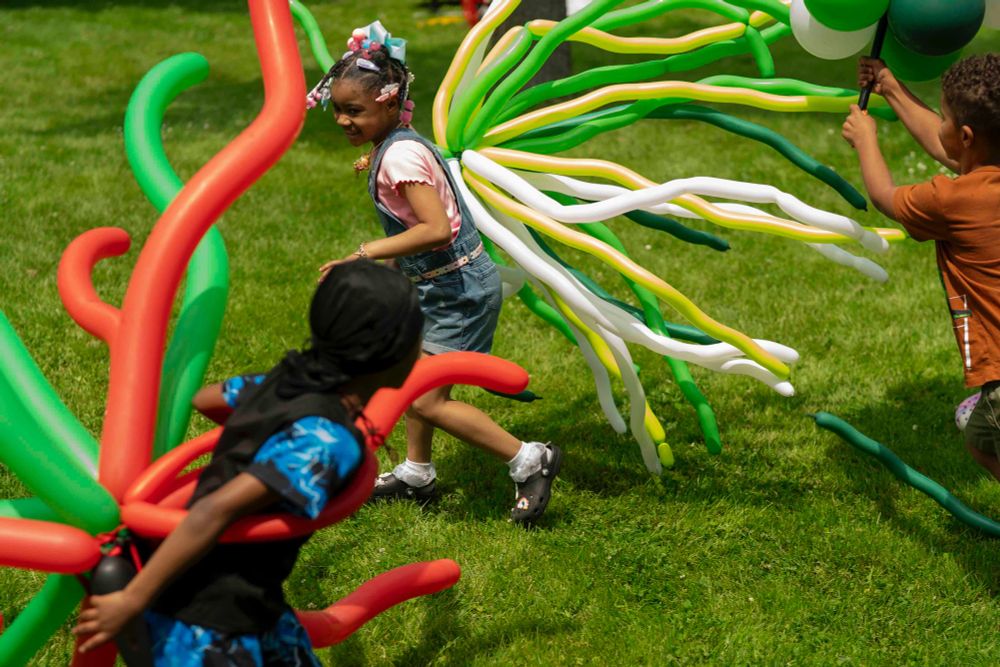 London Rainer, 5, center, eyes her brother Rayquan Whedon, 8, left, as Jesse Harris Jr. 7, chases after her with a balloon tower, making the most of their balloon adornments during the Juneteenth celebration in Buffalo, June 14, 2025. (Libby March/Buffalo News)