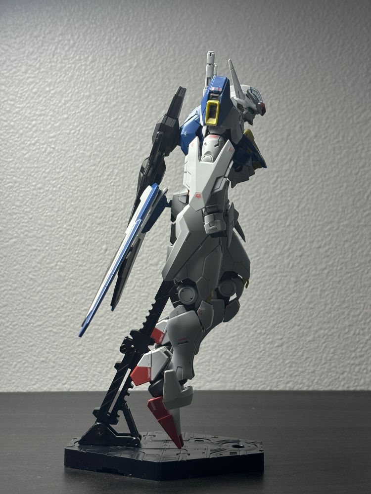 A side view of the Full Mechanics Gundam Aerial - Permet Score 6. It is standing in a slightly menacing pose with all its bit staves attached. 