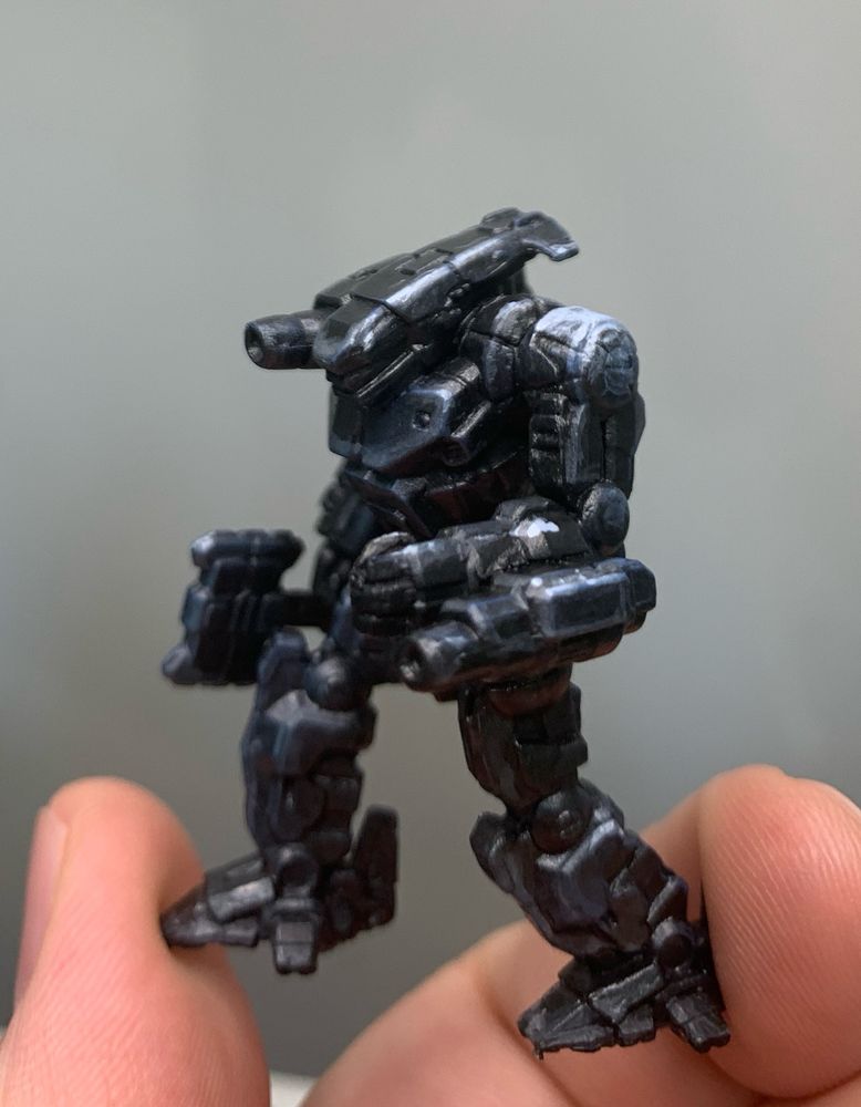 a black hatchet man from battletech. the body itself is a shiny black, but it has light blue and dark blue highlights. the highlights make the mech look like it's armor is reflecting light off the shoulder