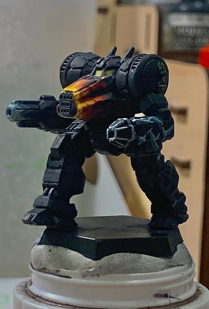 a grand dragon battlemech from battletech, the base color is a dark navy blue. the best is painted with bright flames, emanating from the center of its chest. the left arm, which is in the foreground, is painted with lighting bolts. the lightning bolts are painted light blue. the same shoulder is painted with the word stop in bright yellow. on the right arm, towards the background is painted with a comic blast effect on the tip of the barrel. 