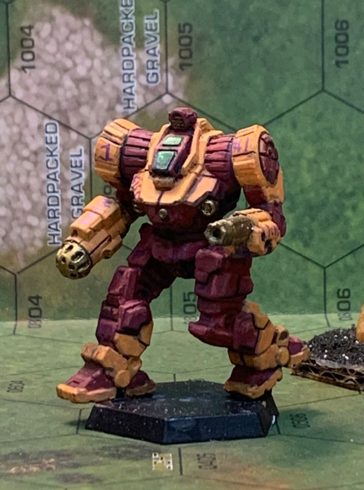 a zeus painted in the colors of the first canopian fusiliers. the body is painted dark red. the shoulders, chest, cowl, arms, and "shoes" of the mech are paired another bright creamy orange. the right and left shoulders are painted with the number 1 in bright purple. the right side of the chest is painted with the word kiss as well, with the same color of paint. 