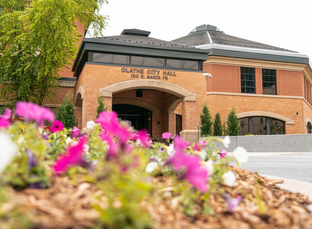 The entrance to Olathe City Hall with purple flowers in the foreground