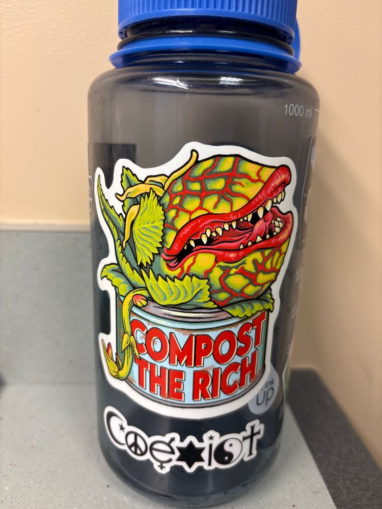 Sticker on a water bottle with a drawing of a “Little Shop of Horrors” style of a large plant with mouth and teeth with “Compost the rich” below. By Will Burrow at https://willburrowsart.com/product/compost-the-rich-sticker/