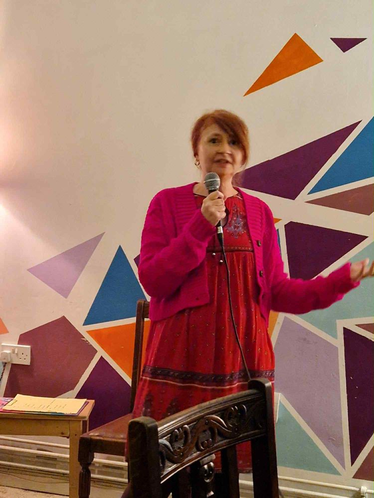 Me in red dress and cardigan at a small open mic event in Indigo cafe in Birkenhead. 