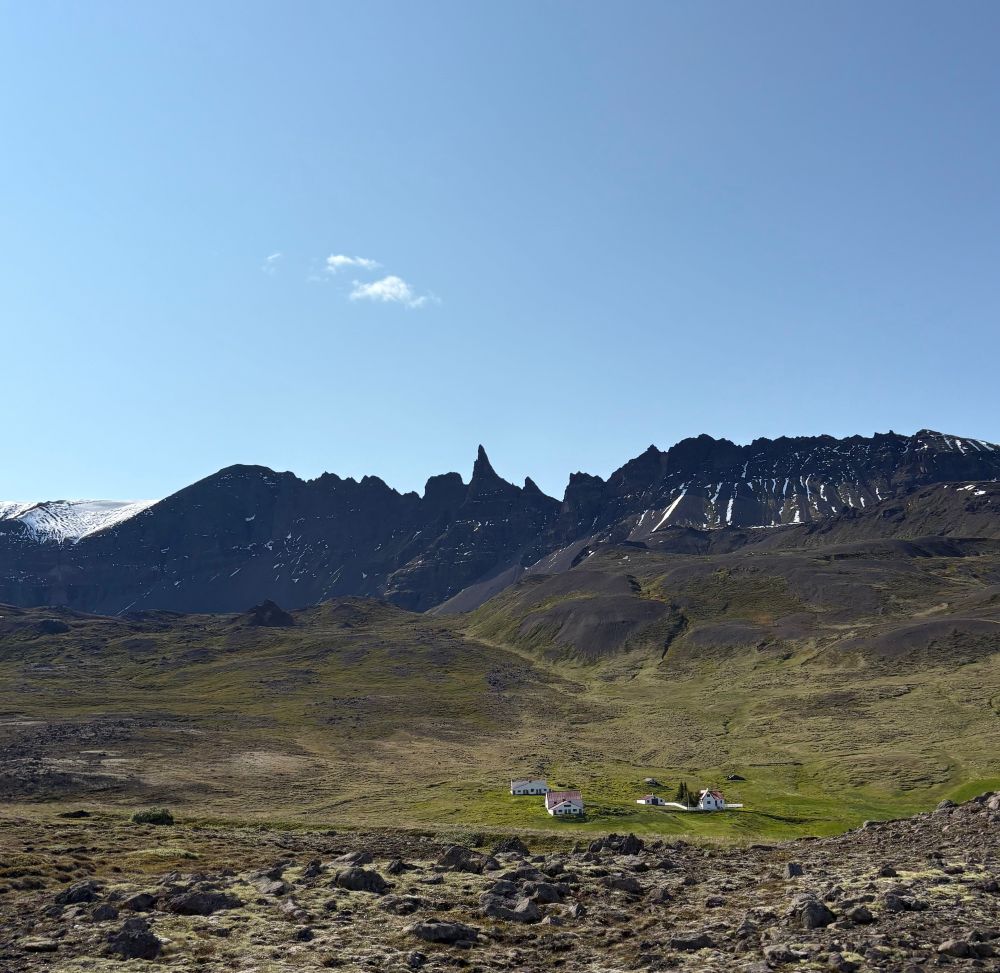 Lava, fields, a farm and a jagged mountain range