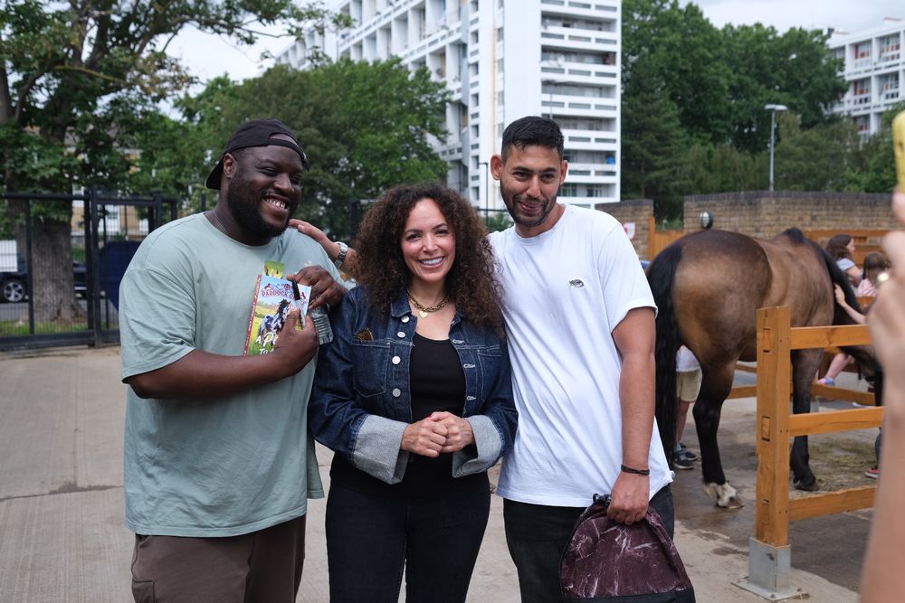 Author JP Rose stood with author Nate Lessore and another (unnamed) author. Pony stable in background. 