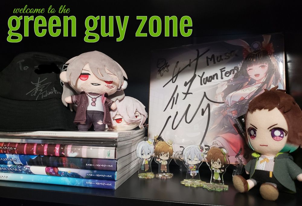 Photo of a shelf where autographs from my two favorite seiyuu (Yusuke Shirai and Shinnosuke Tachibana) are on display. they are surrounded by various merchandise of characters they have voiced. text on the image reads "welcome to the green guy zone"