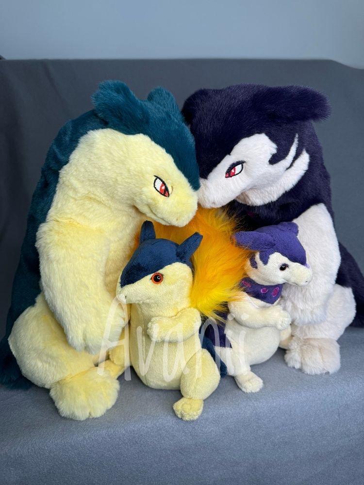 A photo of 4 typhlosion plushies made by Avanii. Two are fluffy and big, the others small and have plastic eyes instead of embroidered. 