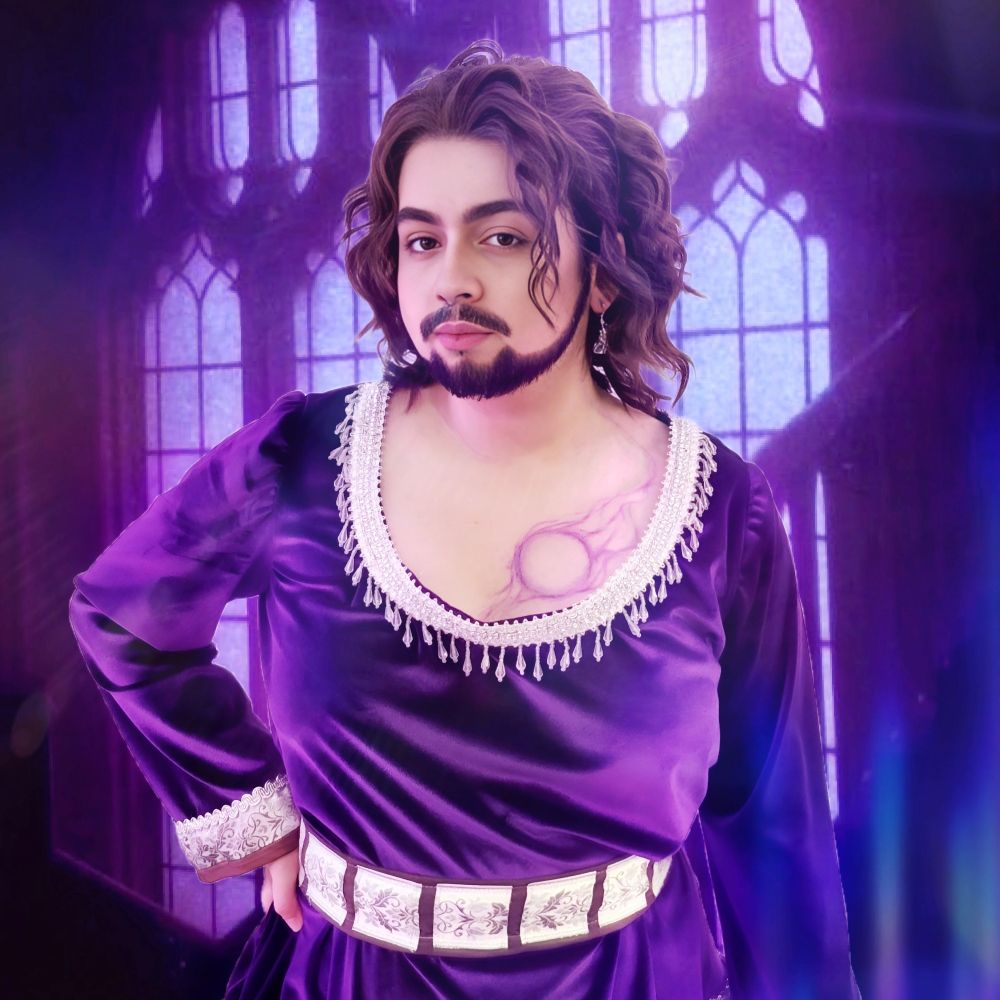 An edited photo of Dan cosplaying Gale from Baldurs Gate 3. The background is gothic windows with purple lighting