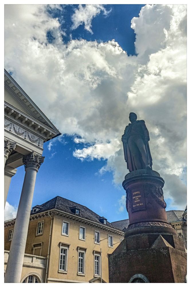 Statue von Großherzog Ludwig I. von Baden auf dem Marktplatz von Karlsruhe. Wilde Wolken am blauen Himmel.
