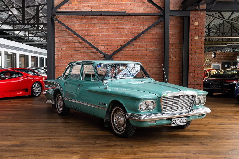A turquoise/teal 1961 Valiant upon which designers went in on every impulse but didn't check in on what the others were doing. Glorious details but the mix of postures make it look like a frog with its nose down and butt up, ready to go to the next lily pad. I love this car. 